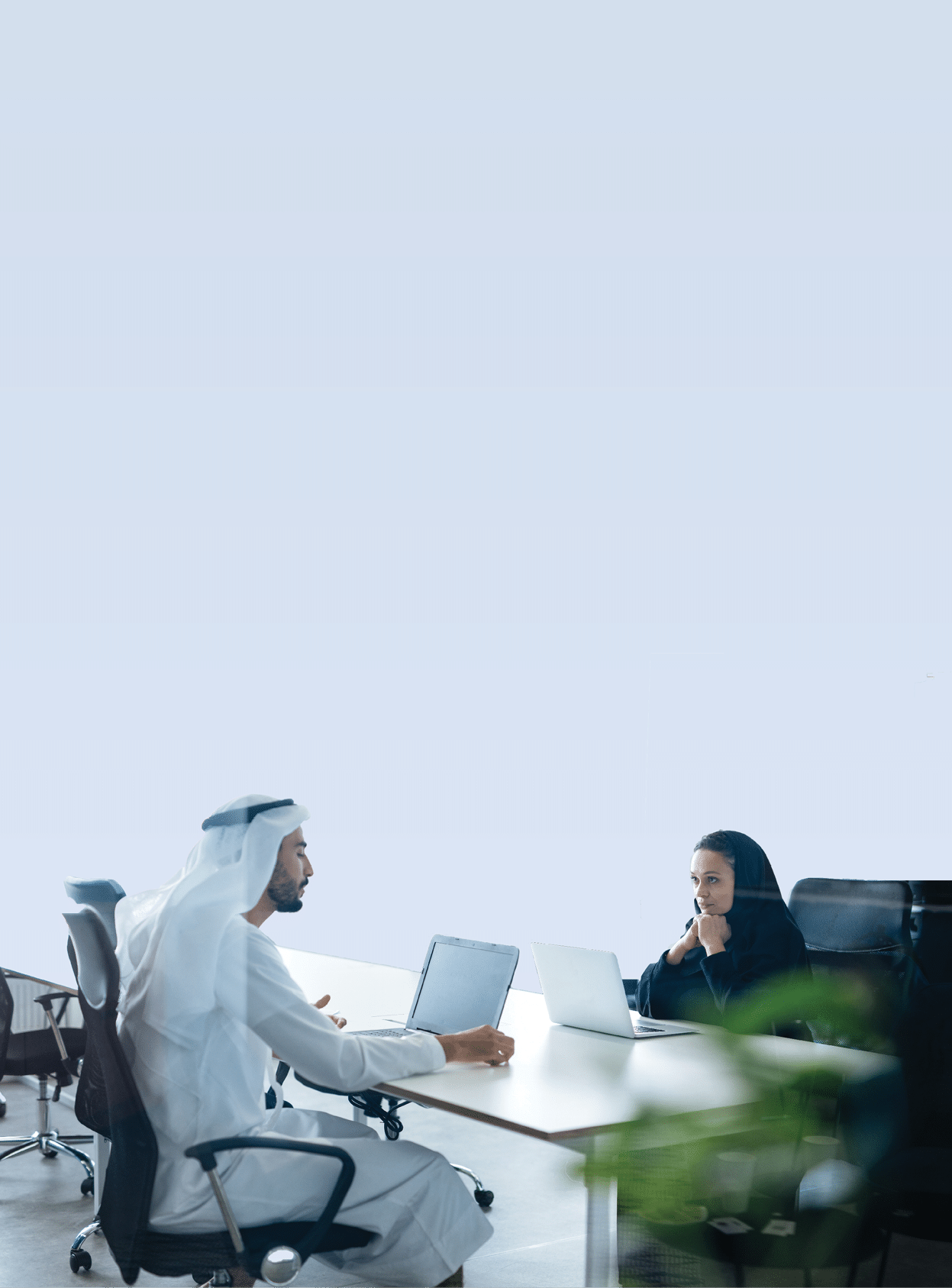 Man and woman with traditional clothes working in a business office of Dubai. Portraits of successful entrepreneurs businessman and businesswoman in formal emirates outfits. Concept about middle east