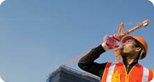 worker man as he drinks from a plastic water bottle on construction site