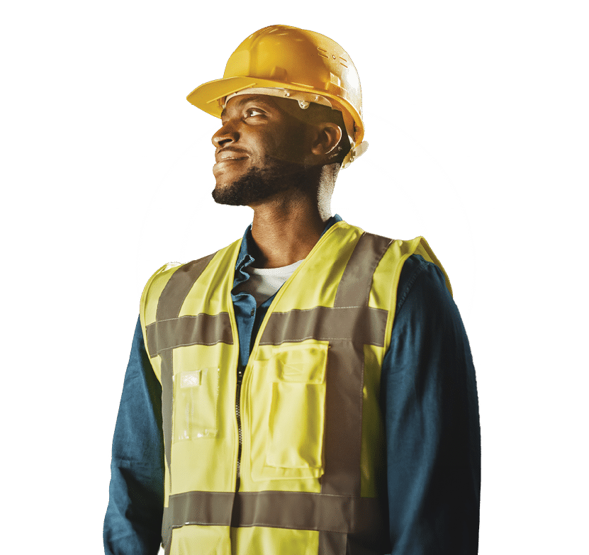 Handsome Professional Worker Wearing Safety Vest and Hard Hat Charmingly Smiling and Looks Into the Distance. In the Background Big Warehouse with Shelves full of Delivery Goods. Medium Portrait