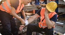 Manual worker feeling pain after having an injury at work while his colleague is helping him.