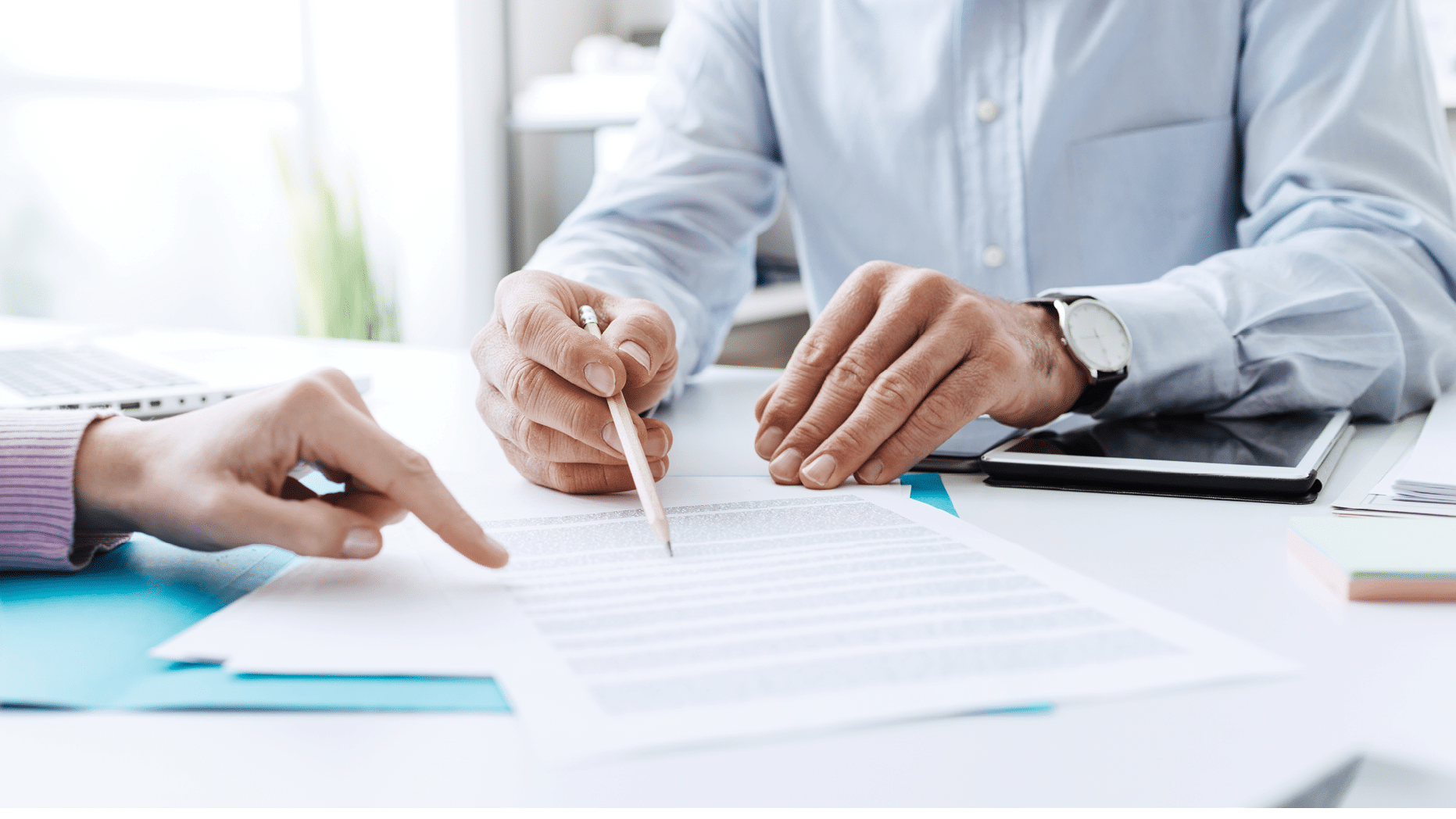 Business people negotiating a contract, they are pointing on a document and discussing together