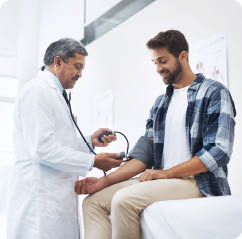Healthcare, patient and doctor with blood pressure test, help and wellness checkup of person at hospital. Medicine, health care expert and Indian man in doctors office consulting medical professional