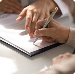 Commercial medicine. Close up of aged woman patient hand signing medical insurance contract at doctor office. Female medic show retired lady client place to put signature on healthcare coverage policy
